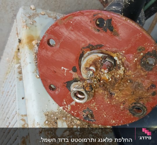 חיבורי חשמל חלודים על לוח מתכת אדום